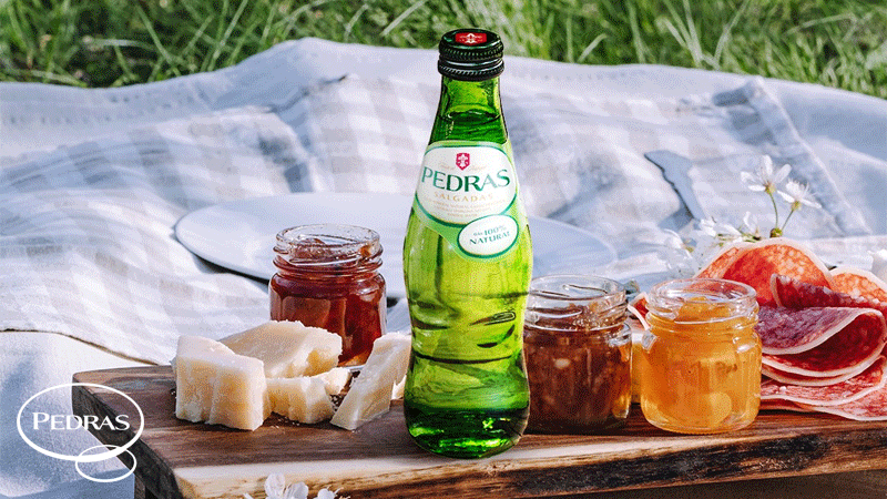 Imagem que mostra uma garrafa de Água das Pedras, uma água mineral com gás 100% natural proveniente de Pedras Salgadas, Portugal.