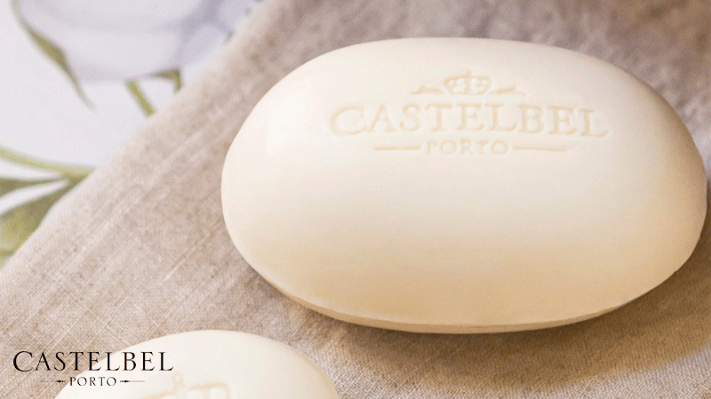 Sabonete de cor clara da marca portuguesa Castelbel, feito à mão e com o logotipo da empresa gravado na superfície do sabonete.