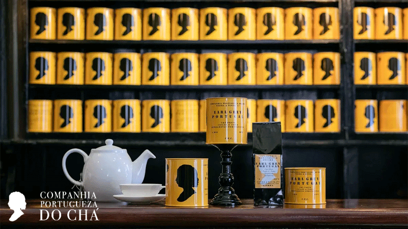 Vista interior da Companhia Portugueza do Chá, uma loja de chá tradicional em Lisboa localizada na Rua do Poço dos Negros, conhecida pelas suas prateleiras repletas de latas de chá amarelas icónicas.