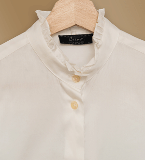 Blusa branca da marca portuguesa CRIVO® com um sofisticado colarinho com folhos e botões frontais discretos.