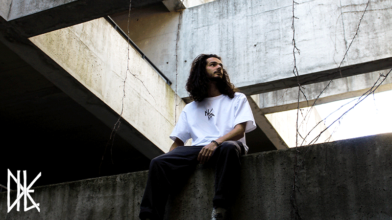 T-shirt branca da marca portuguesa DILE com um ajuste oversize confortável e um logótipo preto minimalista no peito.