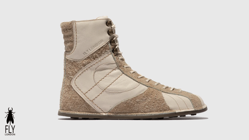 Bota de cano alto da marca portuguesa Fly London para mulher, feita de couro e camurça em tons de bege.