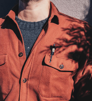 Camisa vermelha sobreposta a camisola cinzenta de lã da marca portuguesa Indagatio.