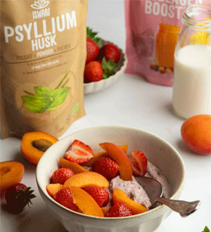Taça com fruta fresca e uma preparação cremosa, acompanhada por produtos da marca portuguesa ISWARI®, incluindo Psyllium Husk, morangos, damascos e uma bebida vegetal.
