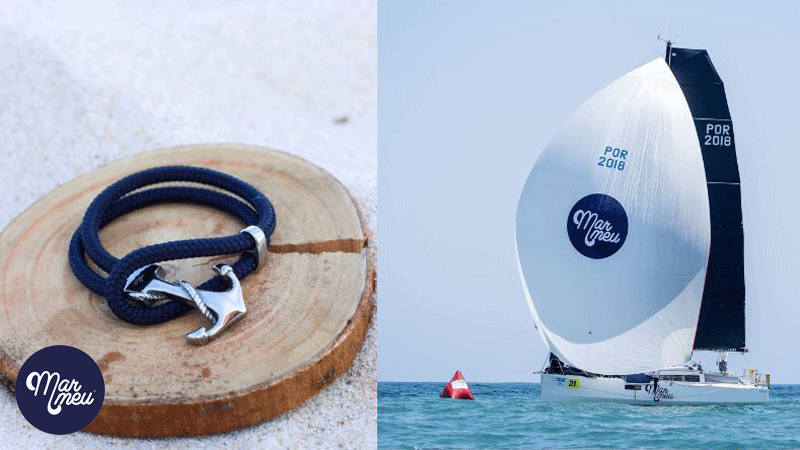 Pulseira de corda azul com um fecho em forma de âncora da marca portuguesa Mar Meu ao lado da imagem de um veleiro com o patrocínio da marca.