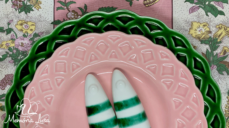 Pratos e sardinhas de cerâmica pintados à mão pela marca portuguesa Memória Lusa. Cada peça é única, com ligeiras variações que refletem o trabalho manual.