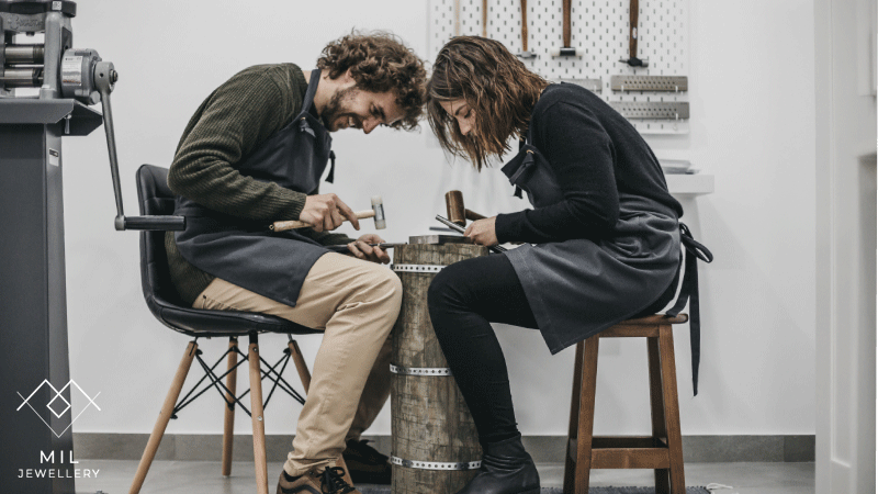 Casal a criar as próprias alianças de casamento através de técnicas tradicionais e materiais sustentáveis com o apoio de profissionais.