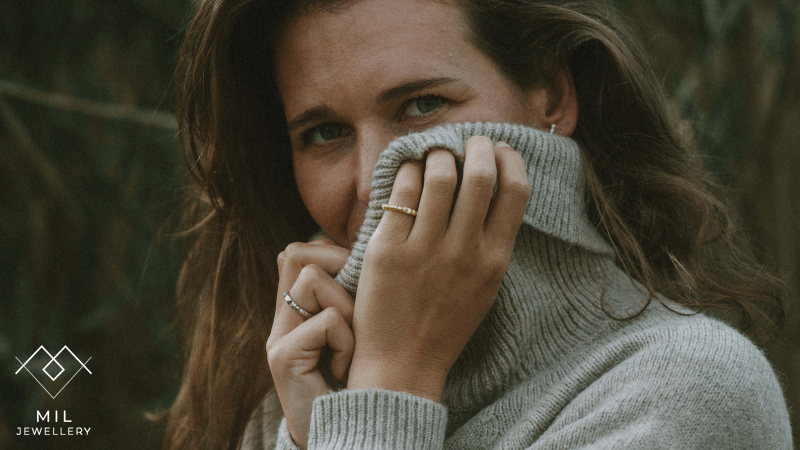 Mulher com anéis e brincos da marca portuguesa Mil Jewellery num estilo minimalista e orgânico, característica central das suas coleções, que frequentemente utilizam prata 925 com banhos de ouro.
