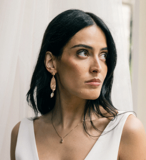 Modelo a usar um colar e brincos da marca portuguesa Mil Jewellery num estilo minimalista e orgânico, característica central das suas coleções, que frequentemente utilizam prata 925 com banhos de ouro e pedras naturais. 