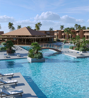 Piscina exterior de um hotel da marca portuguesa PESTANA®, rodeada por palmeiras, espreguiçadeiras e áreas de lazer.