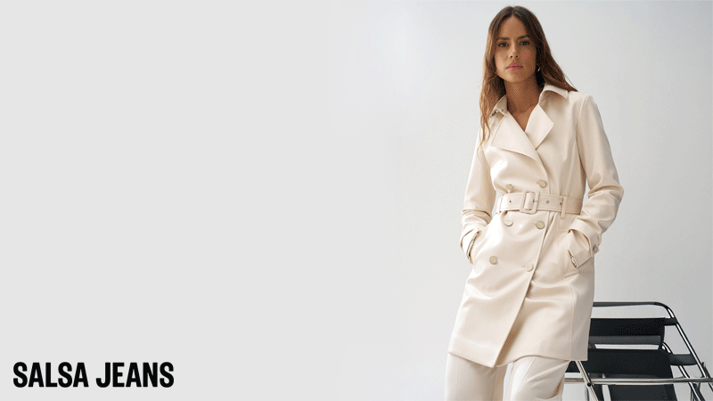 Trench Coat da marca Salsa Jeans em tom cru, caracterizada por um brilho discreto devido ao seu acabamento acetinado. O design inclui um corte regular com linhas intemporais, fecho de botões e um cinto ajustável no mesmo tecido para definir a silhueta.