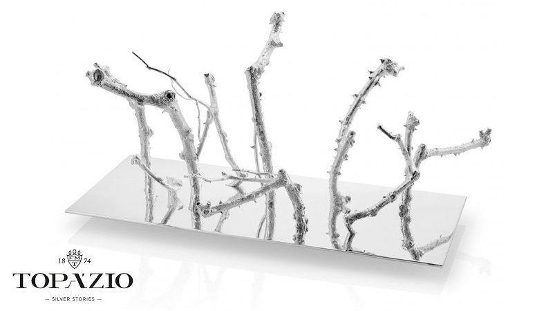 À base completamente espelhada feita em metal com banho de prata foram aparafusados troncos de roseira feitos à semelhança dos originais mas com acabamento rugoso.