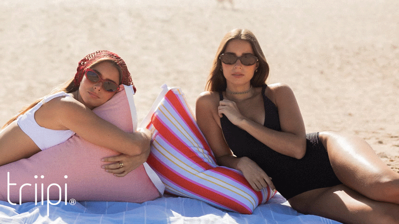 Almofadas de praia Triipi BIG exterior da marca portuguesa Triipi em tecido cor-de-rosa e às riscas coloridas, ideais para relaxar confortavelmente na praia.